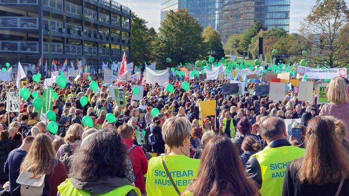 Menschen mit bunten Plakaten demonstrieren vor dem Landtag in Düsseldorf