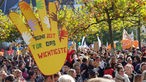 Menschen mit bunten Plakaten demonstrieren vor dem Landtag in Düsseldorf, auf einem steht: "Keine Zeit für das Wichtigste"