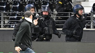 Ein Frankfurter Ultra zeigt Polizeibeamten den Mittelfinger. Nach dem Spiel hatten die Ultras versucht, zum Block der Fans von Saint-Gilloise zu gelangen.