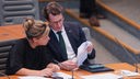 Hendrik Wüst und Mona Neubaur wie sie sich im Plenarsaal des Landtags in NRW unterhalten
