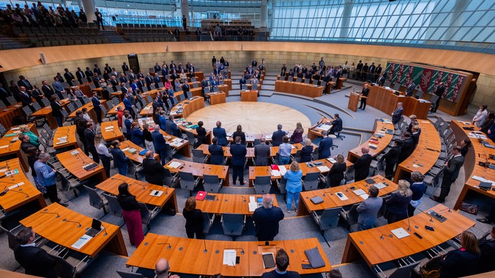 25.10.2023, Nordrhein-Westfalen, Düsseldorf: Die Abgeordneten stehen während einer Schweigeminute für Israel im Plenum des Landtags.