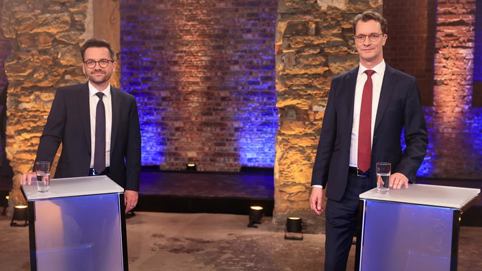 Hendrik Wüst, CDU-Spitzenkandidat und Ministerpräsident von Nordrhein-Westfalen, und Thomas Kutschaty (l), SPD-Spitzenkandidat und Vorsitzender der nordrhein-westfälischen SPD, stehen nebeneinander beim TV-Duell der Spitzenkandidaten