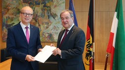 Der Präsident des nordrhein-westfälischen Landtags, André Kuper (l), überreicht Armin Laschet seine Urkunde über die Beendigung des Amtes als Ministerpräsident.