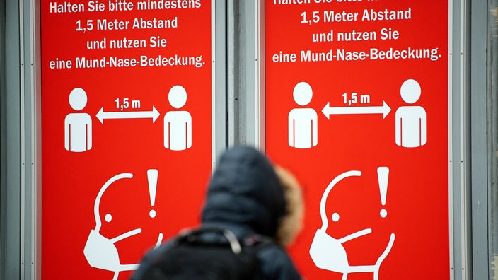 Schilder weisen im Kölner Hauptbahnhof auf die Maskenpflicht hin.