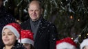 Olaf Scholz hinter Kindern mit Weihnachtsmützen