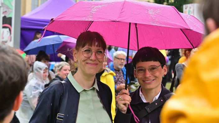 Josefine Paul und Katja Meier stehen zusammen unter einem Regenschirm, 11. CSD in Chemnitz