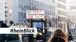 Traktor mit "Es reicht"-Plakat auf dem Frontlader fährt durch Düsseldorf