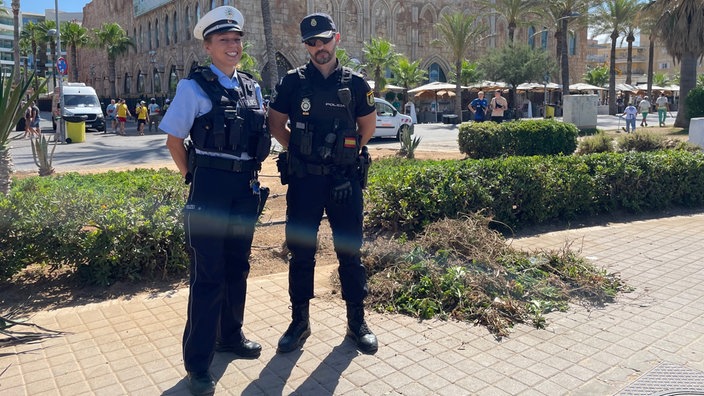 Eine Polizistin in deutscher Uniform steht auf Mallorca neben ihrem spanischen Kollegen