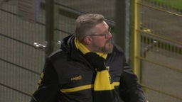 Ralf Hochscherff geht in schwarz-gelbem Outfit durchs Stadion von Alemannia Aachen