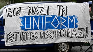 Auf einer Kundgebung in Mülheim an der Ruhr wird 2020 ein Plakat gezeigt mit der Aufschrift "Ein Nazi in Uniform ist immer noch ein Nazi"