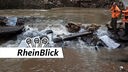 Zwei Helfer schauen auf Wasser, das durch Bad Münstereifel fließt und Schäden angerichtet hat