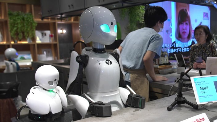 Ferngesteuerte Roboter stehen an einer Theke in einem Café in Tokio