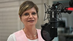 Sarah Philipp (SPD), steht in einem Hörfunkstudio des WDR vor einem Mikrofon
