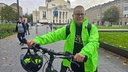 Ein Mann mit grüner Jacke steht neben einem Fahrrad