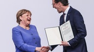 2023, Nordrhein-Westfalen, Köln: Die frühere Kanzlerin Angela Merkel (l, CDU) nimmt von Hendrik Wüst (r, CDU), Ministerpräsident von Nordrhein-Westfalen den Staatspreises des Landes, entgegen.