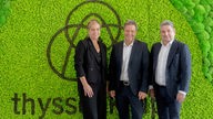 Vor einer grünen Wand mit Thyssenkrupp-Logo stehen NRW-Wirtschaftsministerin Mona Neubaur, Bundeswirtschaftsminister Robert Habeck und der Thyssenkrupp-Vorstandschef Miguel López. Aufnahme vom 05.06.2023
