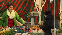 Eine Frau kauft Gemüse auf dem Wochenmarkt in Bedburg ein