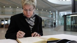 Landtagspräsidentin Carina Gödecke trägt sich ins Kondolenzbuch ein