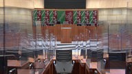 Plenarsaal des NRW Landtags, leere Stuhlreihen mit Plexiglasscheiben dazwischen, Rednerpult