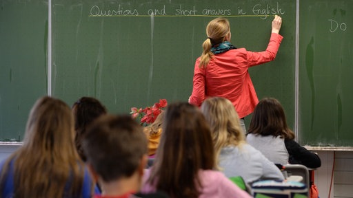 Lehrerin und Schüler im Klassenzimmer (Symbolbild)