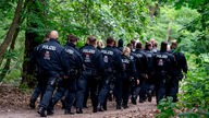Polizisten laufen im Bereich der südlichen Landesgrenze von Berlin