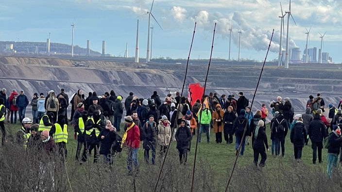Mehrere Aktivisten stehen an der Kante zum Tagebau