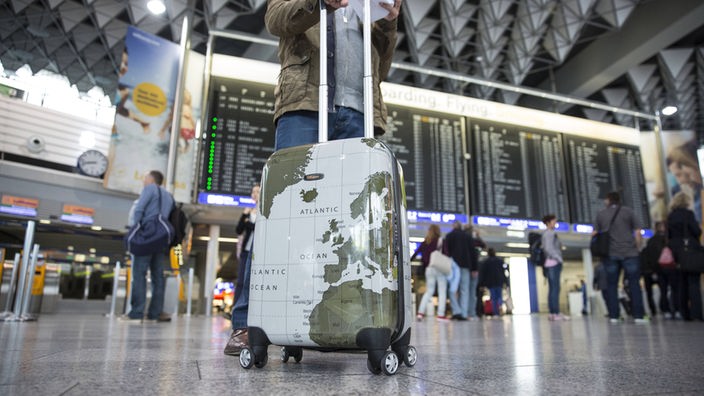 Ein Passagier mit einem Koffer in der Haupthalle des Frankfurter Flughafens