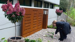 Angela Merkel legt Blumen an der Gedenktafel nieder