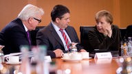 Angela Merkel (CDU) unterhält sich am 19.03.2014 zu Beginn der Sitzung des Bundeskabinetts im Bundeskanzleramt in Berlin mit Bundesaußenminister Frank-Walter Steinmeier (l) neben Bundeswirtschaftsminister Sigmar Gabriel (M, beide SPD)