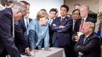Bundeskanzlerin Angela Merkel (CDU, M) spricht mit US-Präsident Donald Trump (r) während der Beratungen beim G7-Gipfel am Rande der offiziellen Tagesordnung.