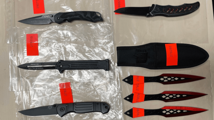 Mehrere Messer, die während der Polizeikontrollen in Düsseldorf beschlagnahmt wurden, liegen aufgereiht auf einem Tisch.