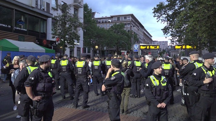 Polizeibeamte kontrollieren Passanten in der Düsseldorfer Altstadt auf Messer und andere Waffen