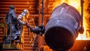 Arbeiter gießen flüssiges Eisen mit einer Temperatur von 1.400 Grad in einer Eisengießerei in vorbereitete Formen