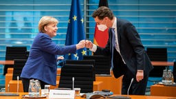 Merkel und Wüst begrüßen sich