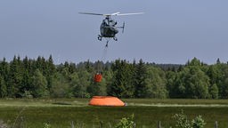 Hohes Venn: Ein Hubschrauber ist zu sehen, der sich nahe der belgisch-deutschen Grenze mit Wasser füllt, um ein Feuer im Hohen Venn zu löschen. Mehr als 170 Hektar sind in Flammen aufgegangen, weshalb in dem Gebiet ein Löschhubschrauber eingesetzt werden