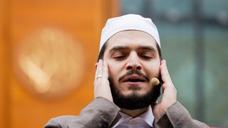 14.10.2022, Nordrhein-Westfalen, Köln: Muezzin Mustafa Kader, Imam der Moschee, ruft in der Zentralmoschee der DITIB Muslime zum Gebet