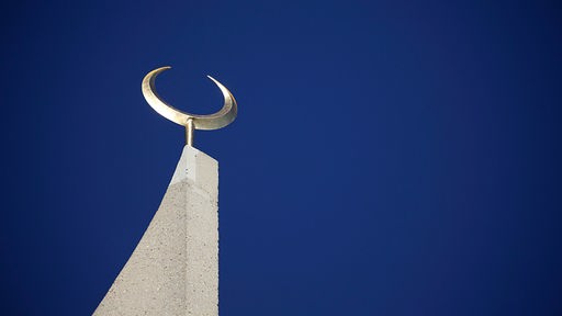 Ein Halbmond steht auf der Spitze eines Minarettes der Moschee der Ditib