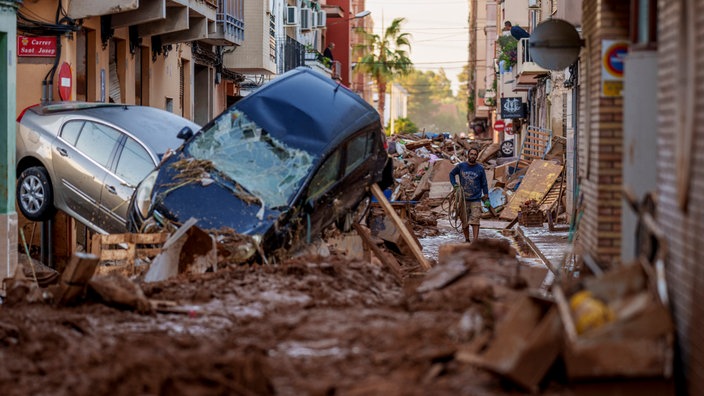 Ein Mann geht am Samstag durch eine von Überschwemmungen betroffene Straße in Valencia nach dem schweren Unwetter