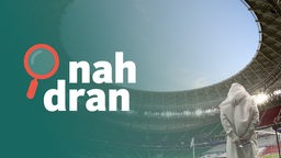 Mann mit traditioneller Kleidung steht in Fuball-Stadion in Katar. Daneben das Podcast-Logo: Schriftzug "nah dran", daneben eine kleine Lupe.