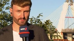 Das Bild zeigt WDR-Reporter Erik Butterbrodt vor der Leverkusener Brücke