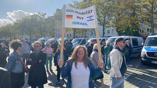 Eine Frau hält ein Schild mit "Solidarität mit Israel" auf einer Demo in Köln