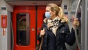 Frau mit Mund-Nasenschutz in der Bahn