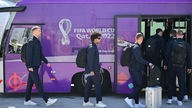 Mitglieder der deutschen Mannschaft, darunter Deutschlands Torhüter Manuel Neuer (L) und Deutschlands Stürmer Serge Gnabry (2. L), steigen nach der Ankunft am Flughafen in Doha, Katar, in einen Bus ein