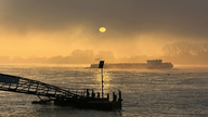 Nebel auf dem Fluss mit leichter Sonne, die sich auf dem Wasser spiegelt