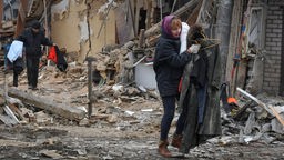 Saporischschja in der Ukraine an Neujahr 2023: Anwohner tragen ihre Habseligkeiten, als sie ihr Haus verlassen, das nach ukrainischen Angaben bei einem russischen Raketenangriff zerstört wurde.