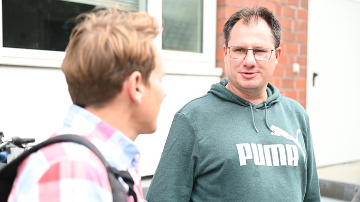 WDR-Reporter Jörn Kießler (l) spricht mit Manuel Diekmann (r)