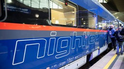 Der neue Nightjet im Bahnhof von Wien, am Gleis stehen vereinzelt Menschen