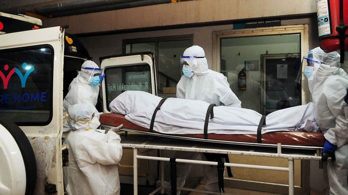 Nipah-Virus in Indien: Menschen in Schutzkleidung transportieren eine Leiche ab.