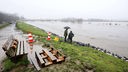 Journalisten stehen am gesicherten Ruhrdeich und schauen auf das Hochwasser der Ruhr