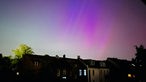 Über Kölner Häusern strahlen Polarlichter